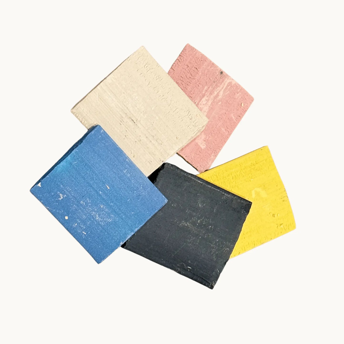 Pink, Ivory, Blue, Black and Yellow tailors chalk on a plain background