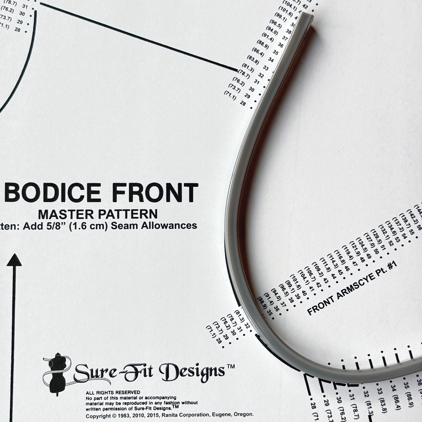 An aluminum flexible ruler that is placed on top of Sure Fit Designs' bodice pattern along the armhole curve