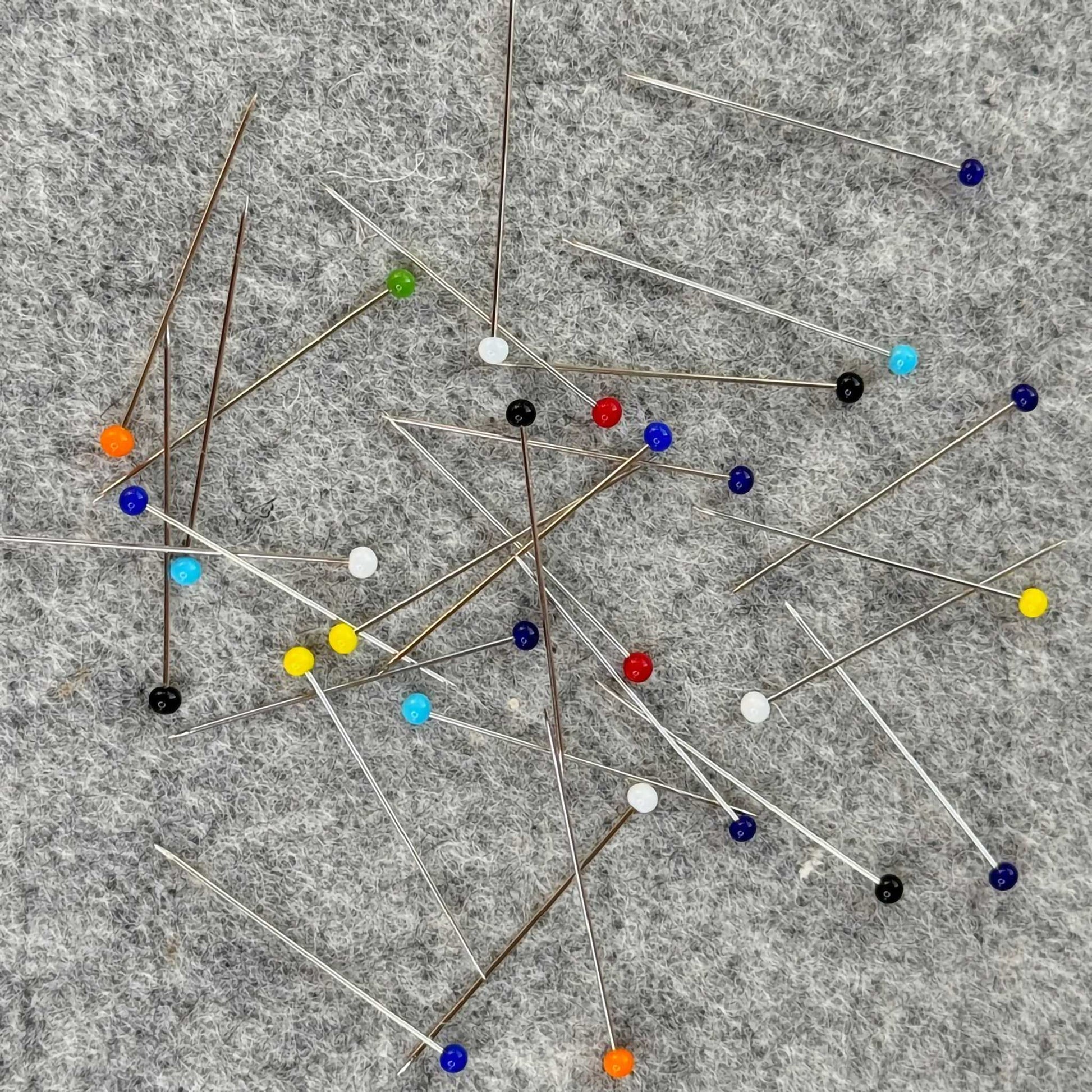 Colorful pins scattered on a gray surface