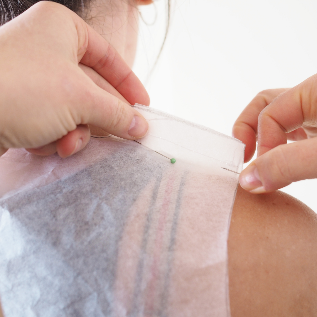 a shoulder back with a pattern made of patterntrace paper pinned over the shoulder