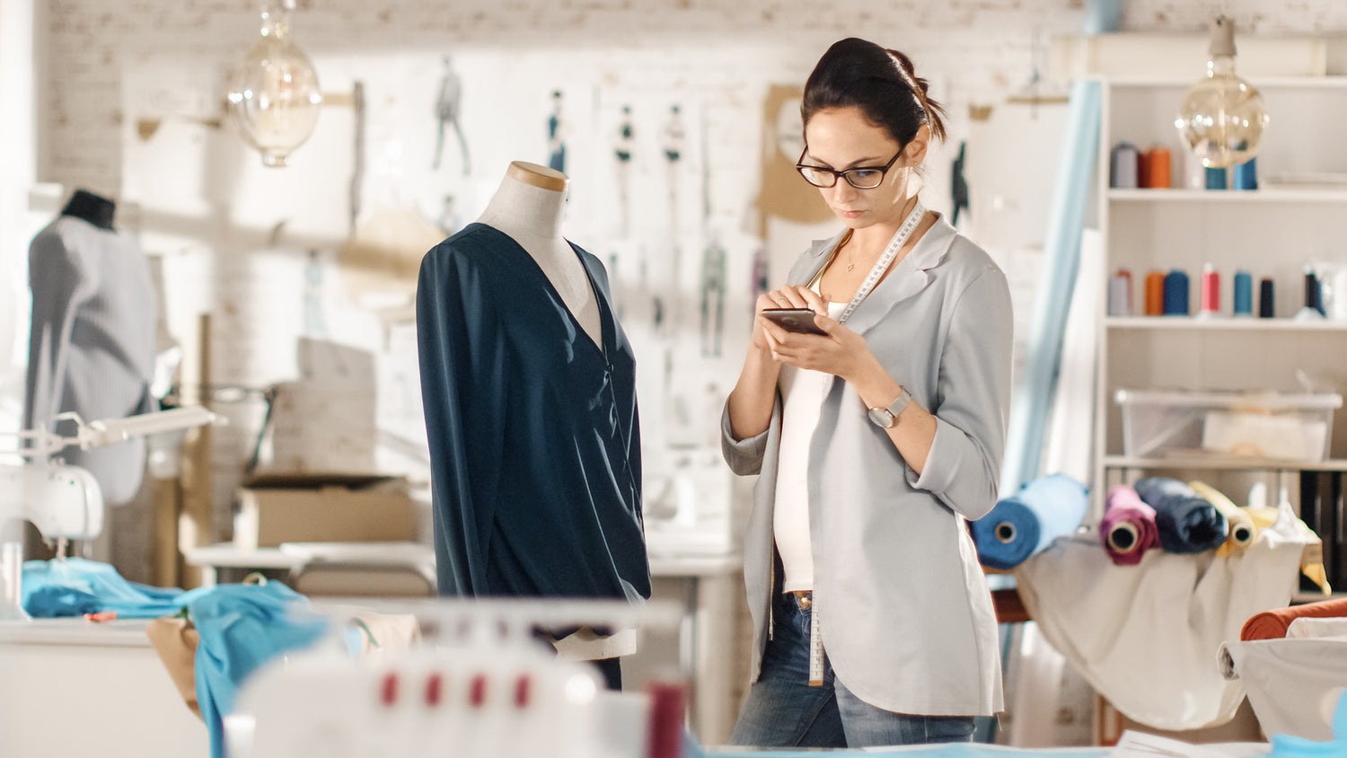 Photograph of a beautiful fashion designer studying the making of a garment