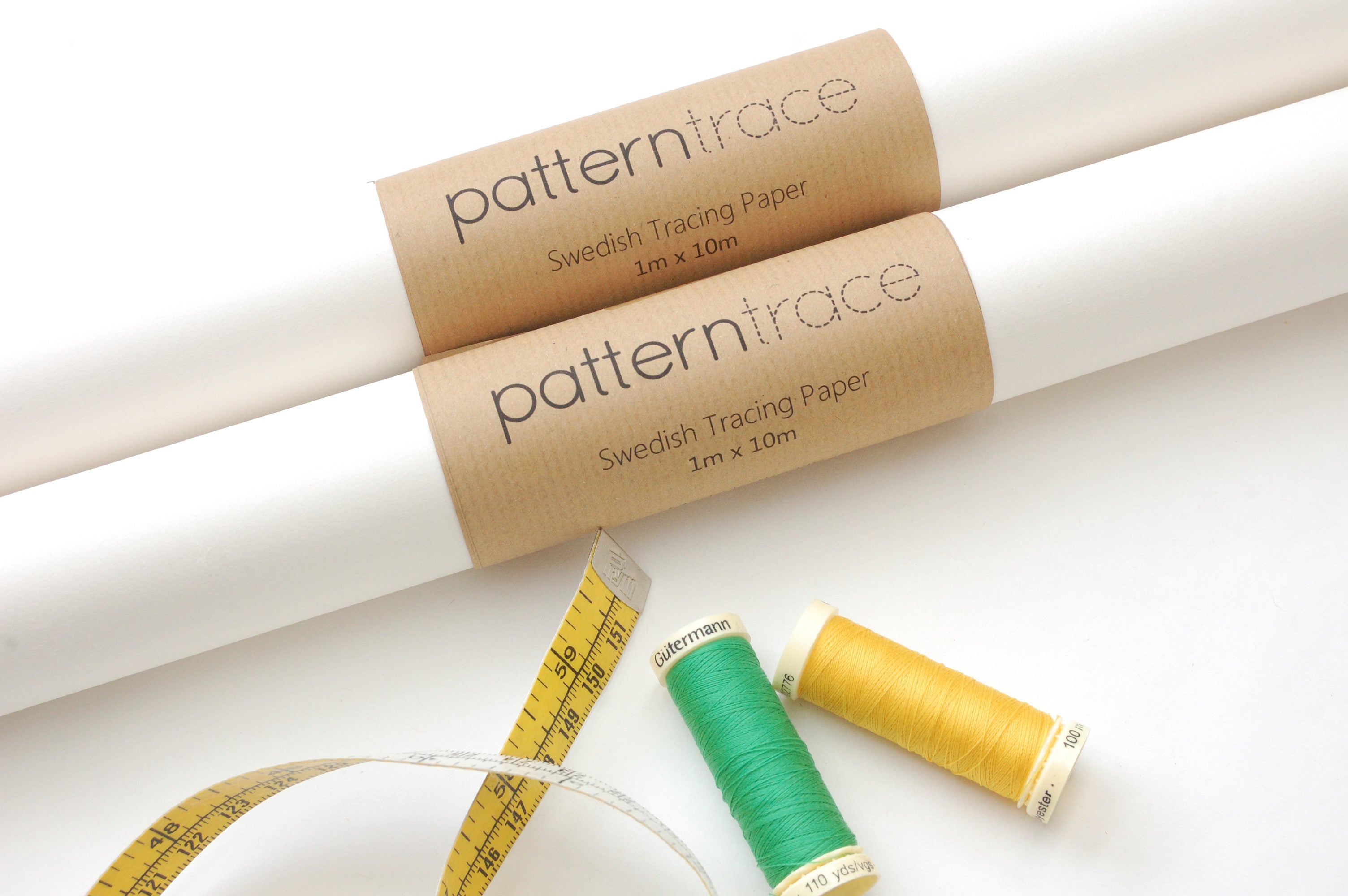 Two rolls of patterntrace swedish tracing paper with a green and yellow spool of thread