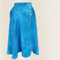 Blue skirt with button details on a beige background