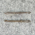 Two bodkins on a textured gray surface