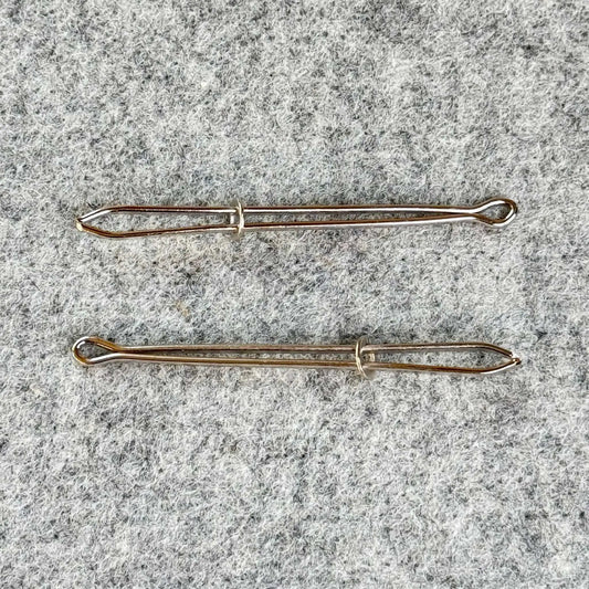 Two bodkins on a textured gray surface