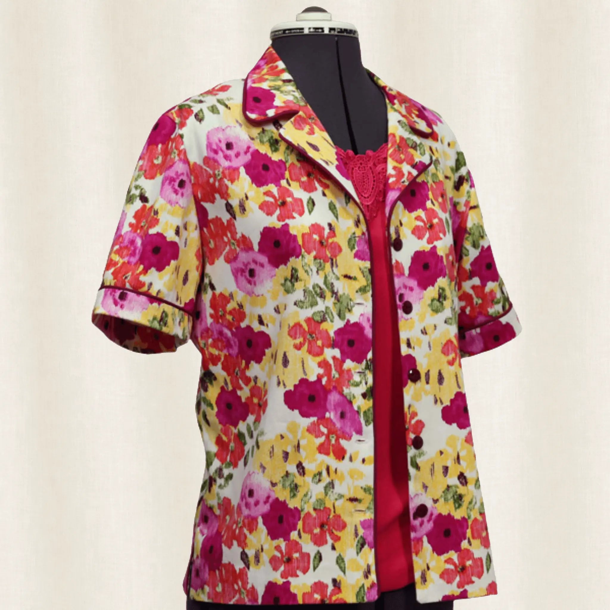 Colorful floral button up shirt on a mannequin against a plain background