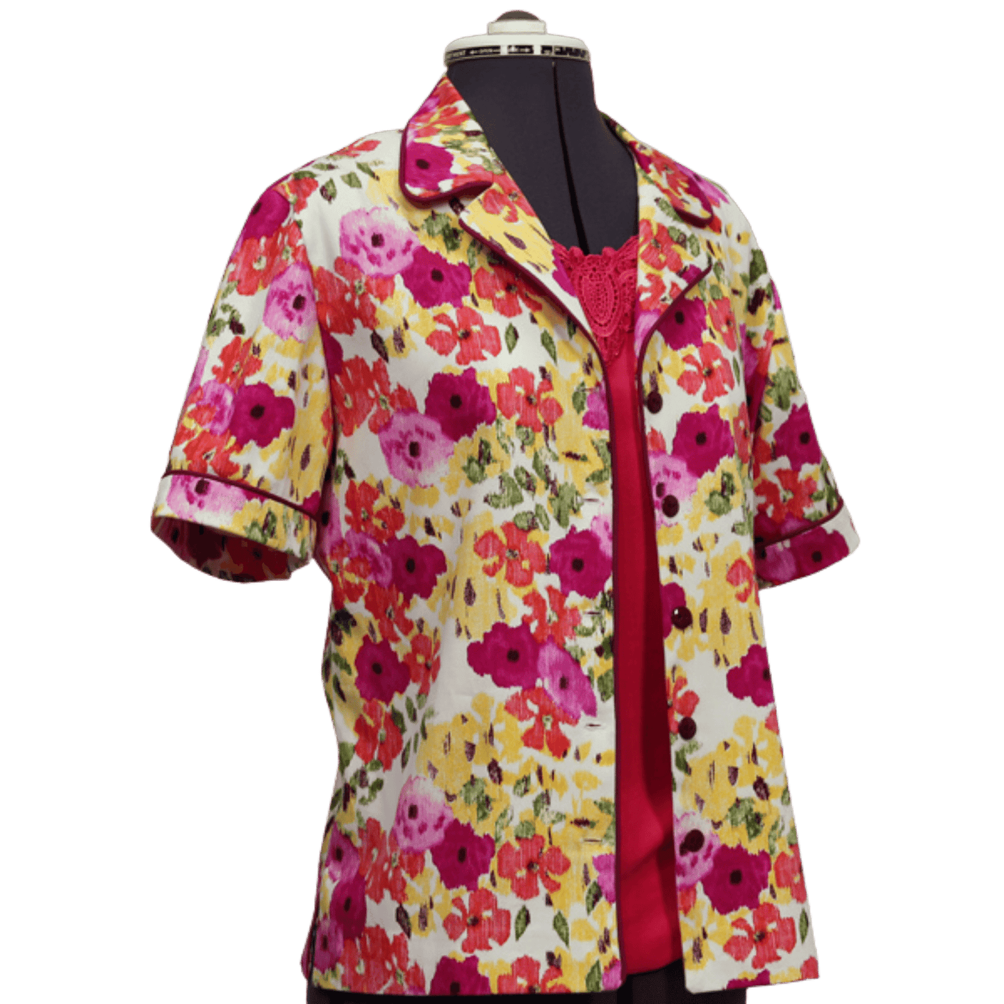 A colorful button up shirt of yellow, fuscia, orange, pink flowers on a white background 