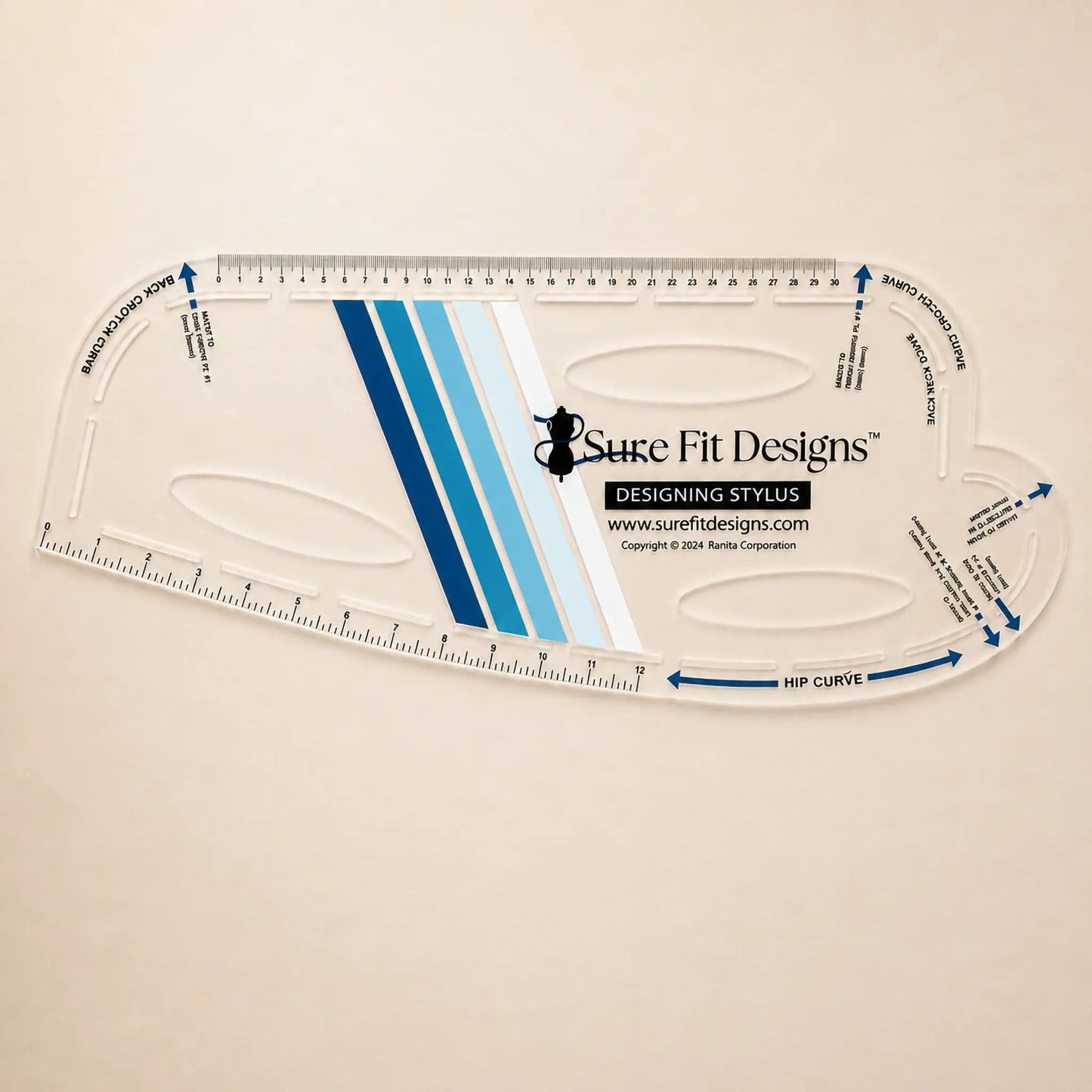 A clear acrylic quilting ruler with blue and white striped center design, featuring the Sure Fit Designs logo and brand website, displayed on a light beige background.
