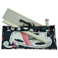 Set of sewing tools including a ruler, pattern paper, and a floral-patterned pouch on a white background