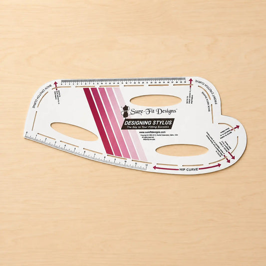 Sure Fit Designs Designing Stylus hip curve measuring tool on a light wood background.