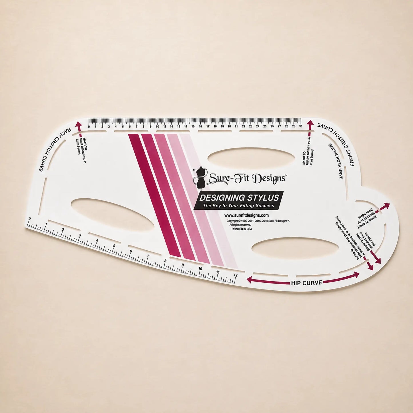A Sure-Fit Designs Designing Stylus measuring tool for hair extensions, shown on a light beige background. The white plastic tool features magenta and pink gradient stripes, black text, and measurement markings.