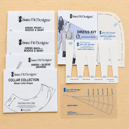 A sewing pattern kit from Sure Fit Designs laid out on a light wood surface, including instruction booklets, collar shape templates, and armhole template pieces.