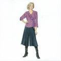 Woman wearing a purple top and dark blue skirt with black knee-high boots on a white background