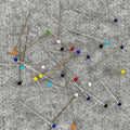 Colorful pins scattered on a gray surface