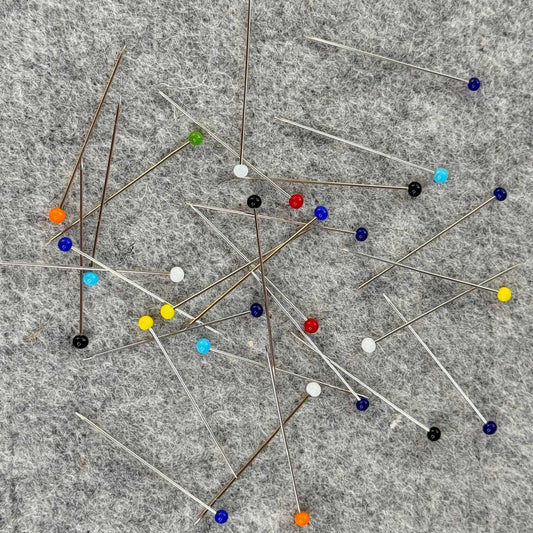 Colorful pins scattered on a gray surface