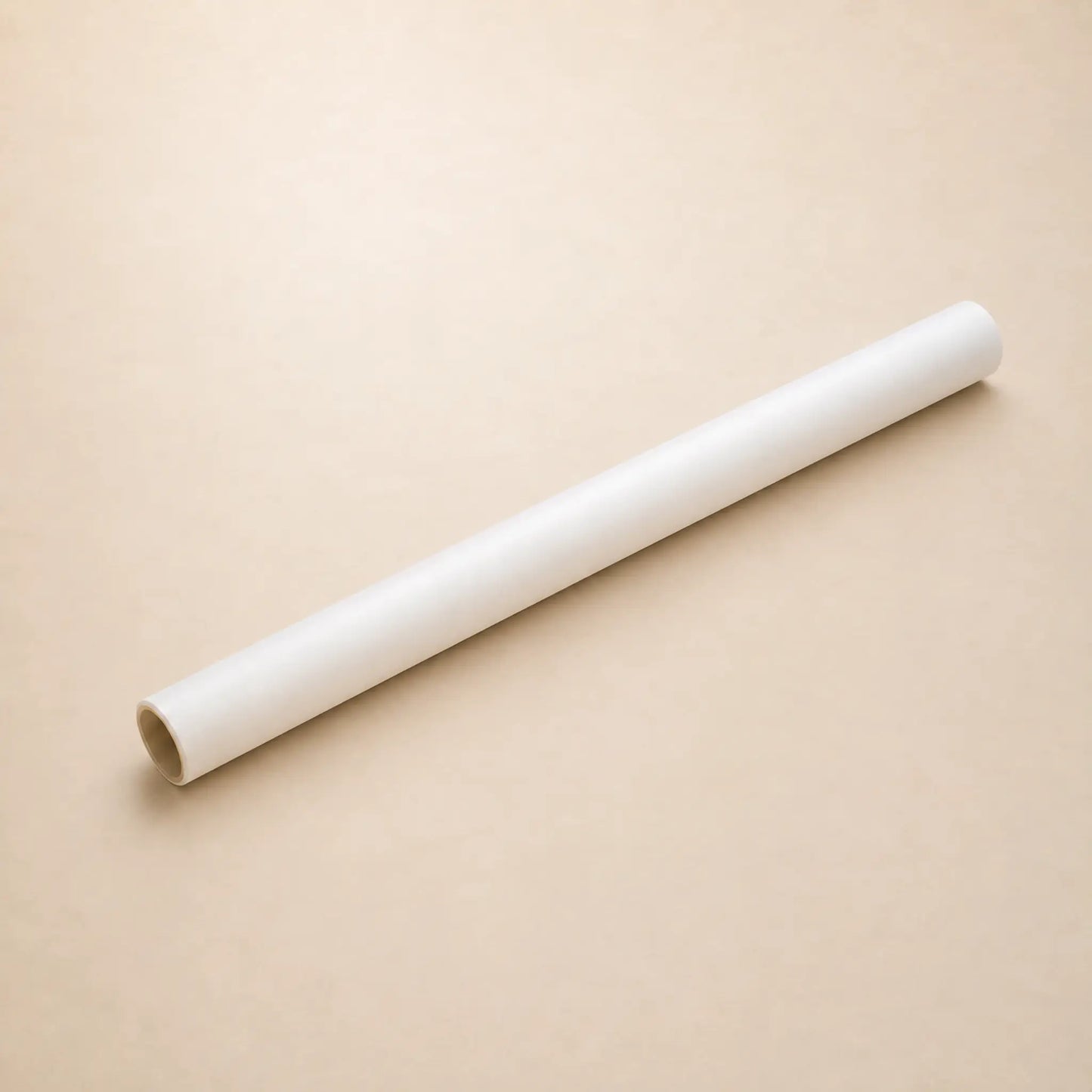 A white roll of Hahnemuhle tracing paper diagonally on a plain beige background.