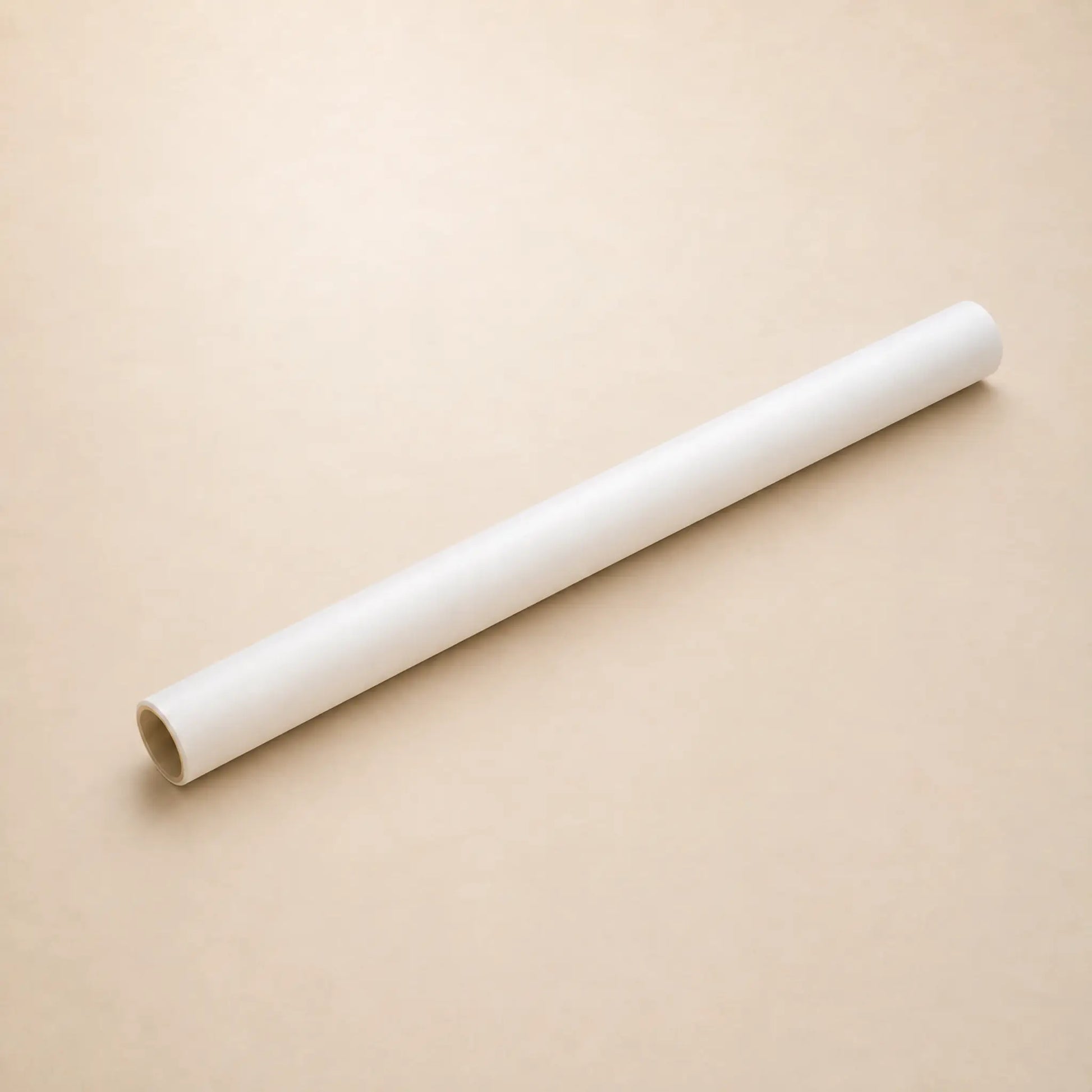 A white roll of Hahnemuhle tracing paper diagonally on a plain beige background.
