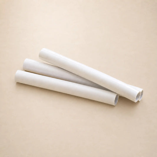 Three white rolls of Hahnemuhle tracing paper  arranged diagonally on a plain beige background.