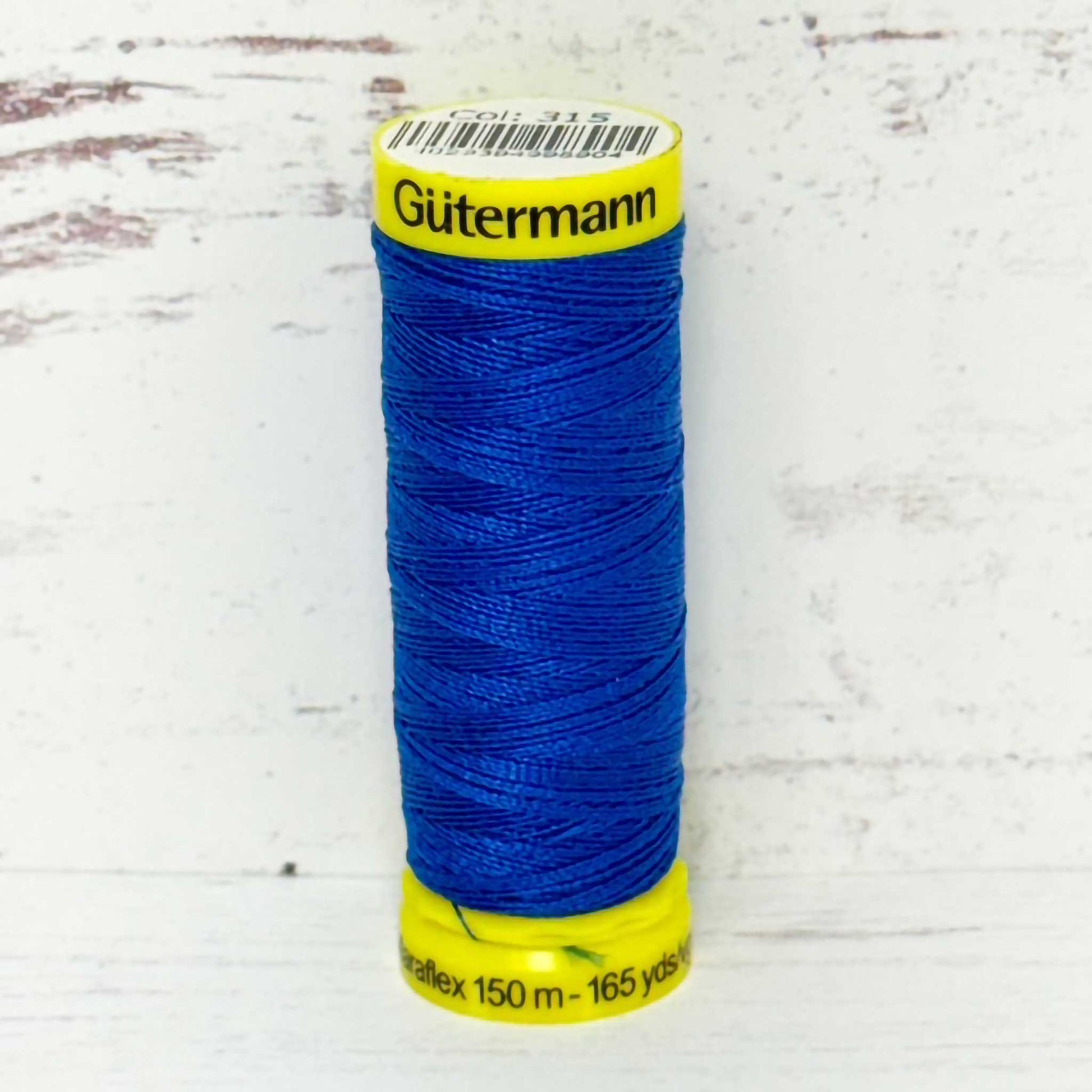Blue spool of Gutermann thread on a white background