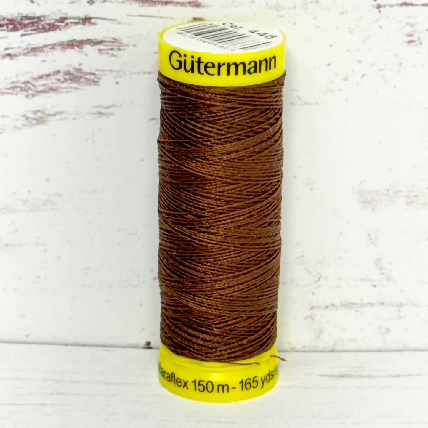 Spool of Gutermann thread on a light wooden background