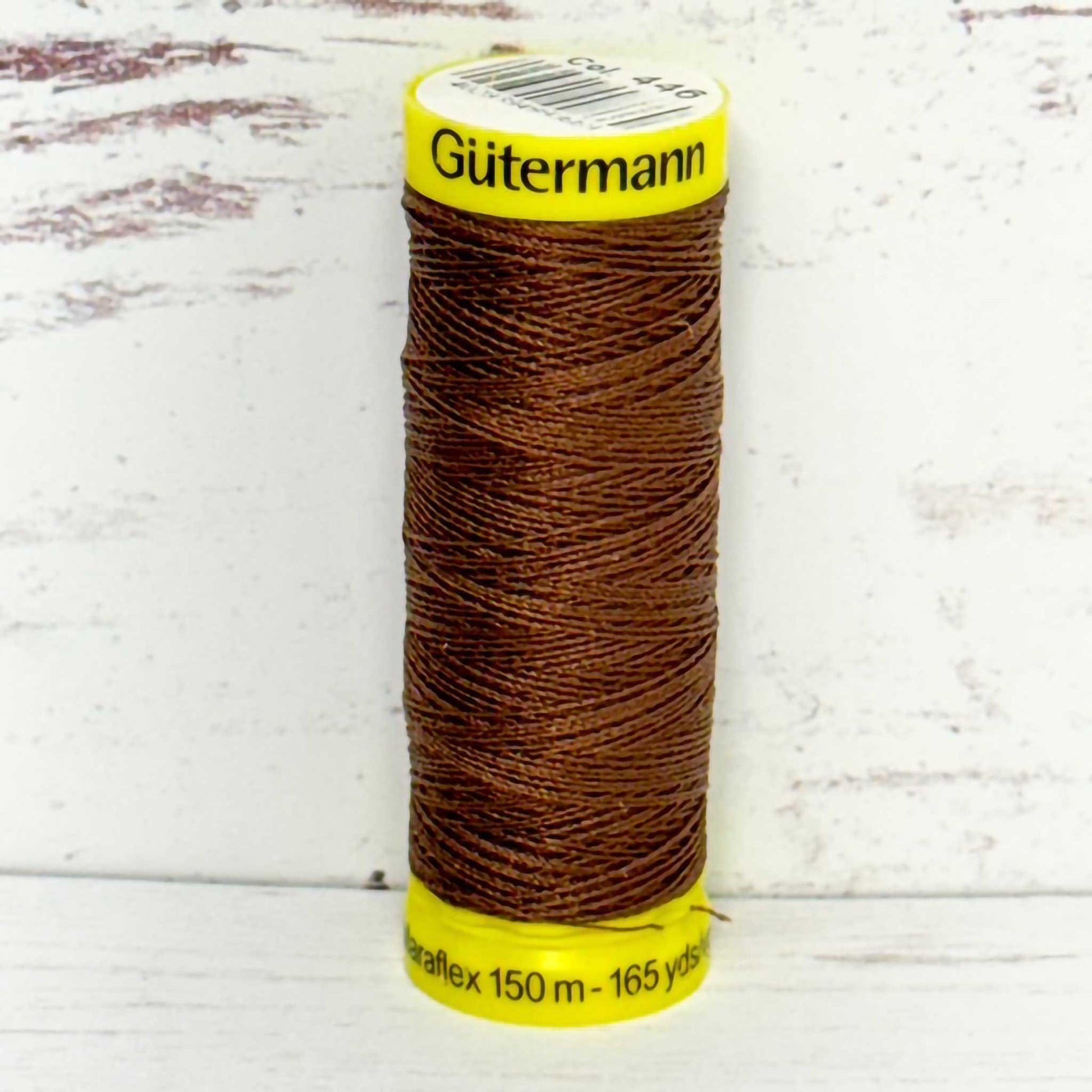 Spool of Gutermann thread on a light wooden background
