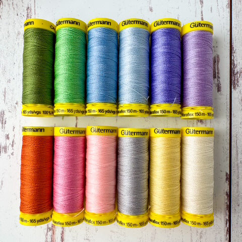 Set of colorful Gutermann thread spools on a wooden surface