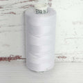 Spool of white thread with 'Seralon' branding on a wooden surface