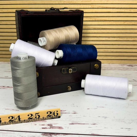 Wooden thread box with spools of thread on a wooden surface
