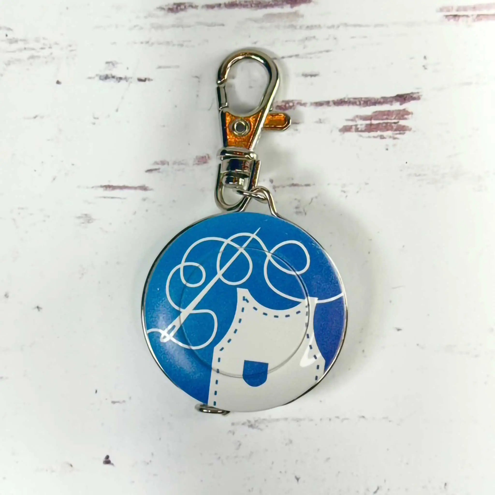 Round blue and white tape measure with a design on a light gray background
