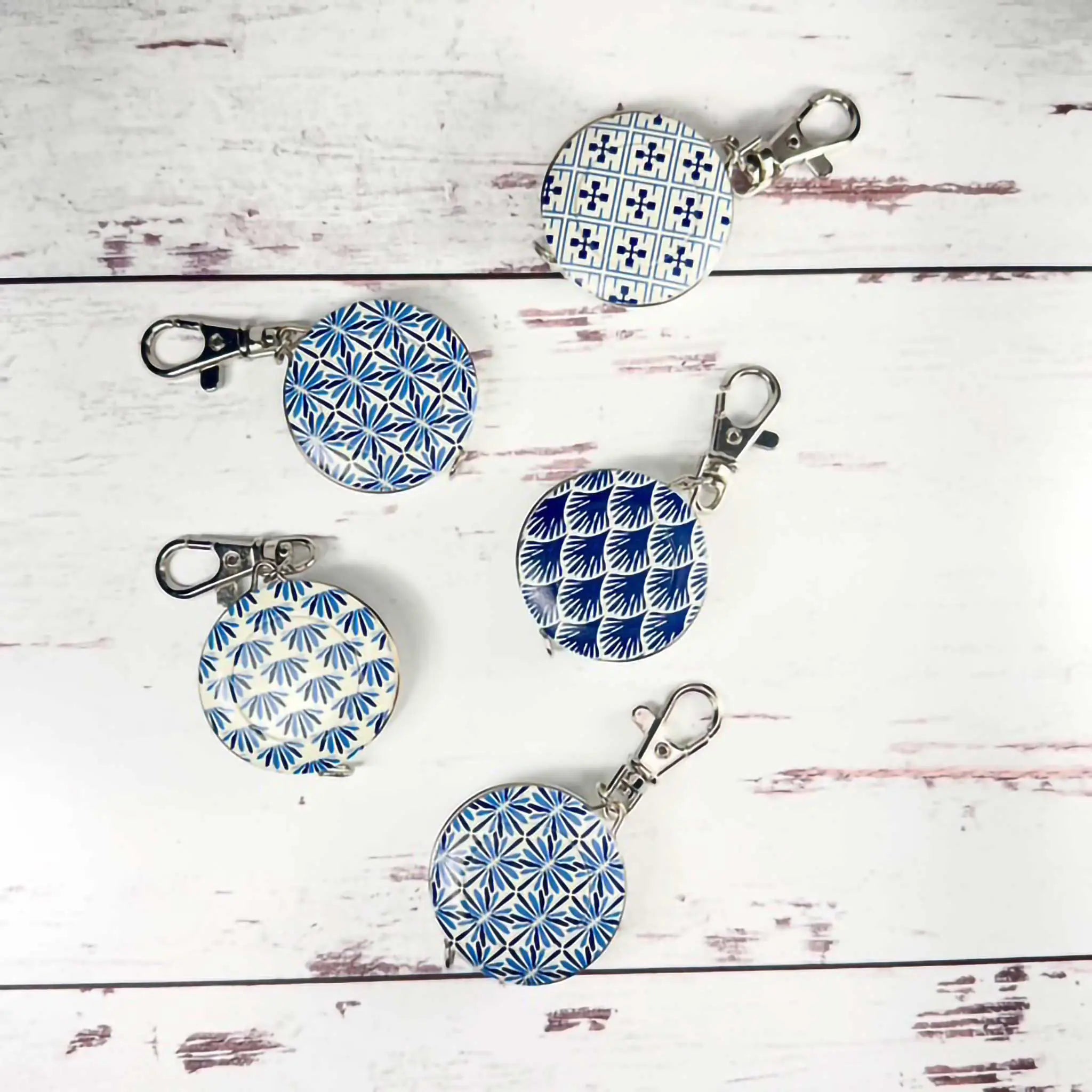 Set of blue and white patterned tape measures on a wooden surface