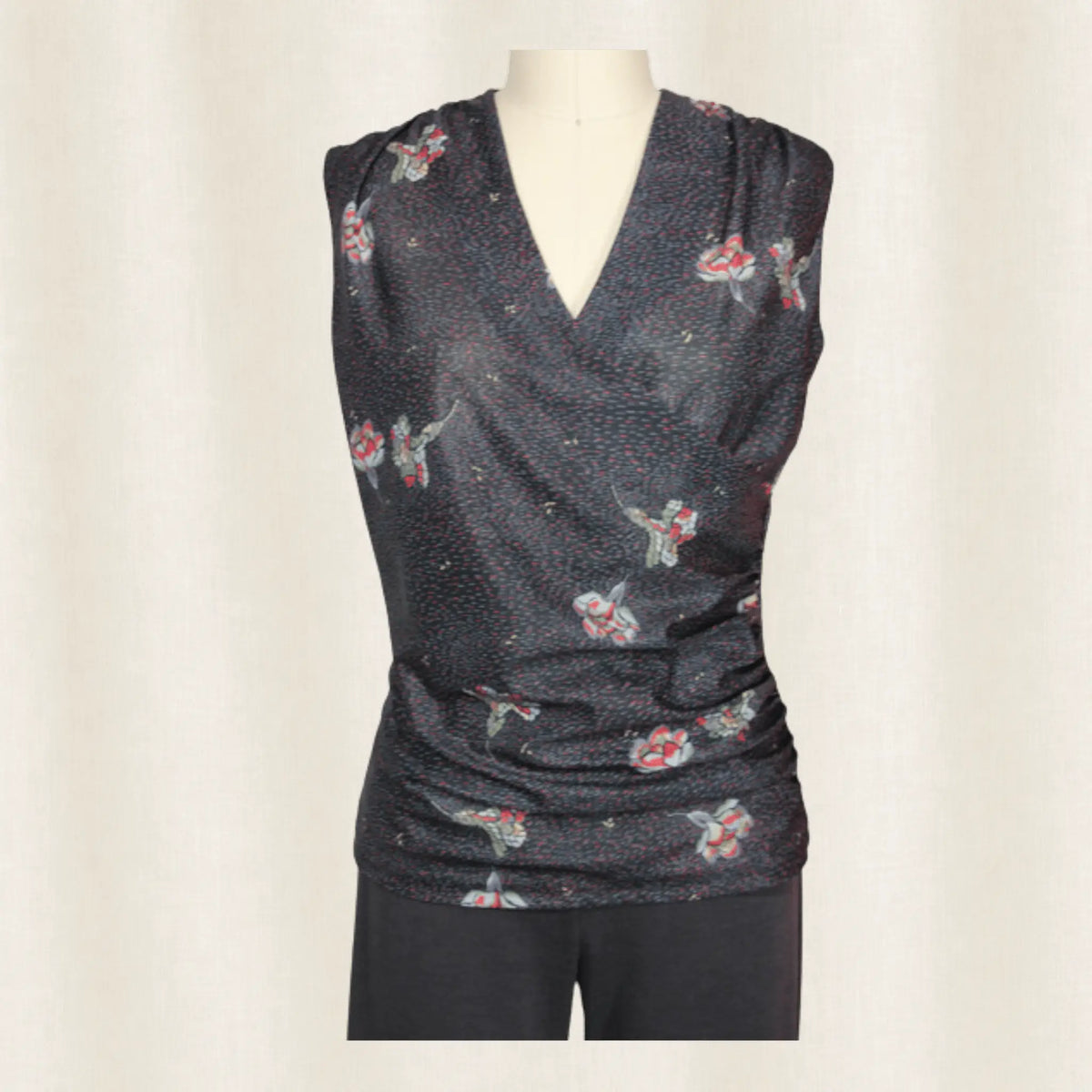 Dark gray sleeveless top with floral pattern on a mannequin against a plain background