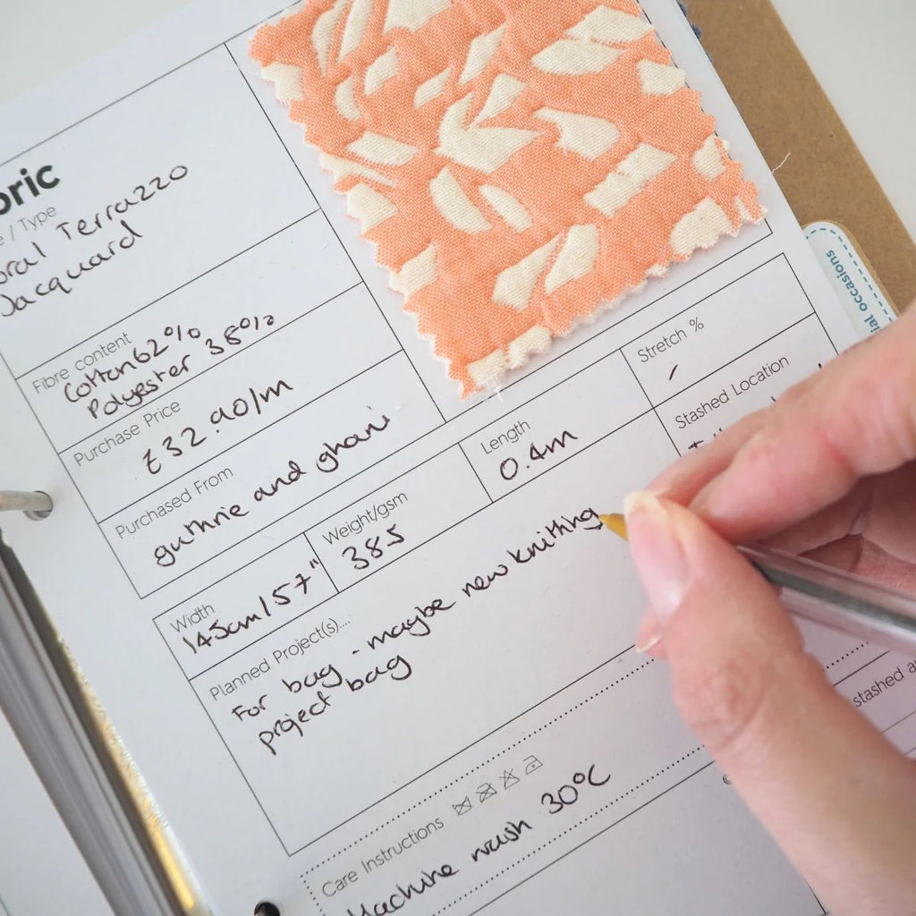 A page in a fabric stash book with categories to fill in fabric details.  There is a swatch of orange and cream fabric in the upper right corner of the page
