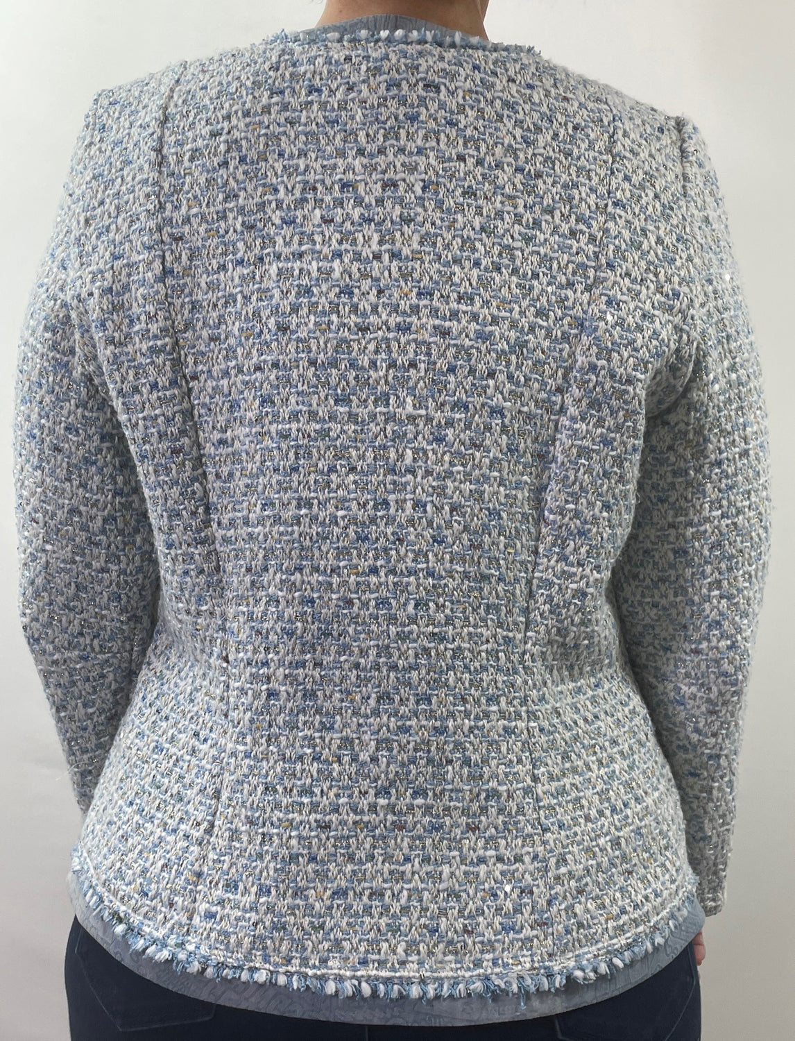 A close up of the back of a mid zipper on a jacket made of blue brocade fabric