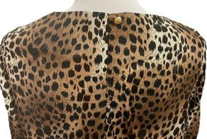 a close up back view of a long sleeved blouse on a mannequin that is made of cougar print fabric