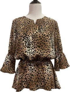 A digital sewing pattern for a long sleeved blouse on a mannequin that is made of cougar print fabric, it is gathered around the waist